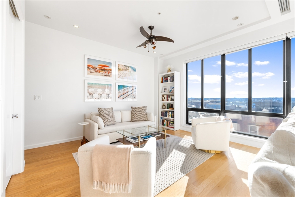 36 A Street, Unit 5C Boston, MA 02127 - Photo 11 of 25 a living room with furniture and a large window