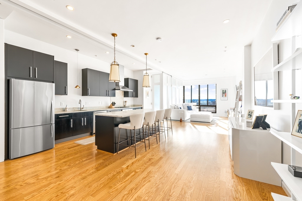 36 A Street, Unit 5C Boston, MA 02127 - Photo 2 of 25 a kitchen with stainless steel appliances a refrigerator a stove a sink dishwasher with a dining table and chairs