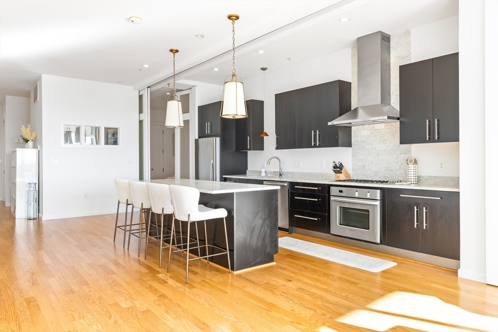 36 A Street, Unit 5C Boston, MA 02127 - Photo 4 of 25 a kitchen with stainless steel appliances kitchen island granite countertop a sink and cabinets