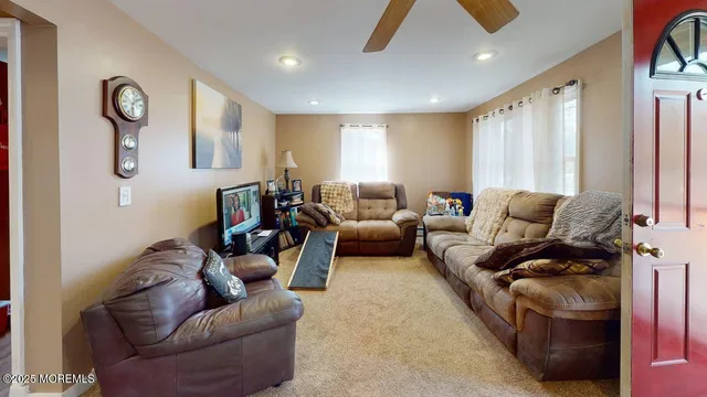 a living room with furniture ceiling fan and a window