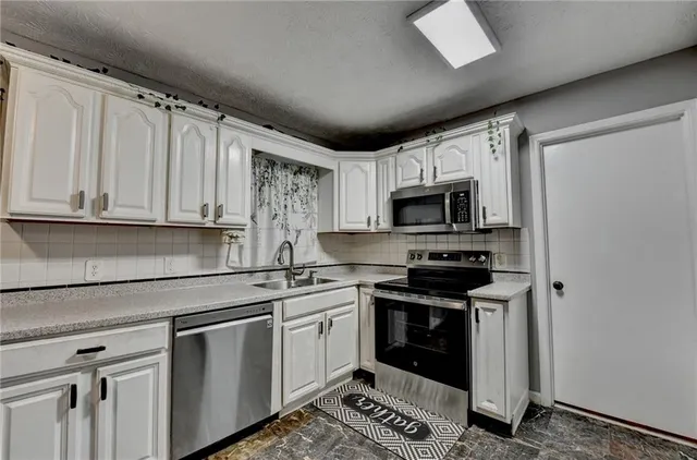a kitchen with stainless steel appliances granite countertop a stove a sink and a refrigerator