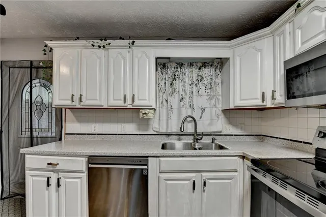 a kitchen with stainless steel appliances granite countertop a sink stove and cabinets