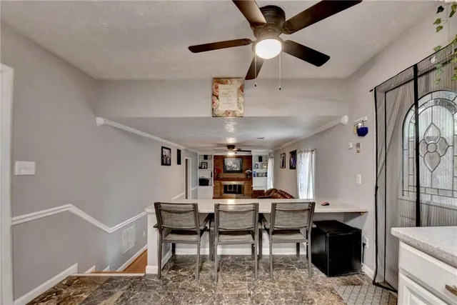 a living room with furniture a chandelier fan and a window