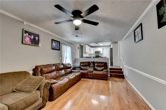 a living room with furniture and a ceiling fan