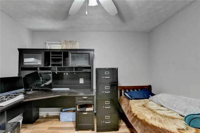 a bedroom with a bed and a computer on a desk