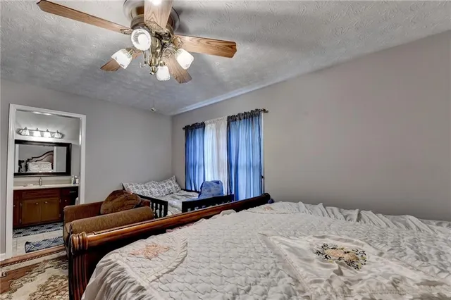 a bedroom with a large bed and a chandelier