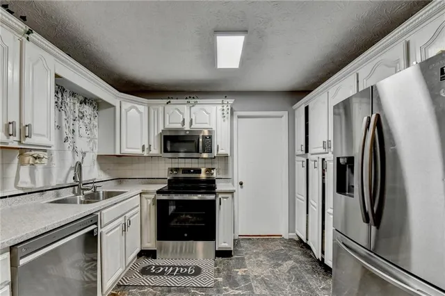 a kitchen with stainless steel appliances a refrigerator stove and sink