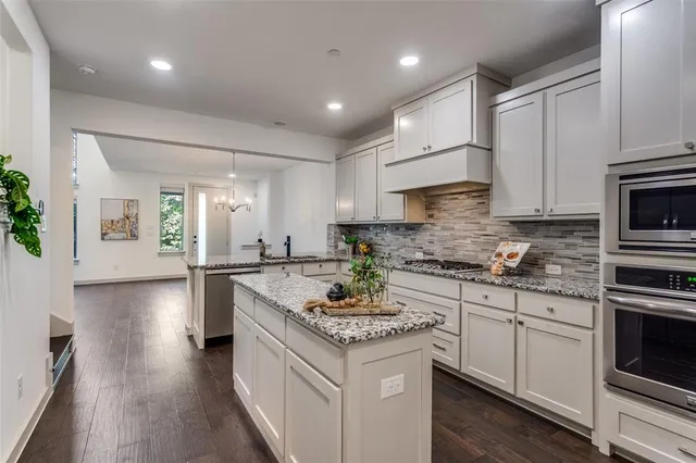 a kitchen with stainless steel appliances granite countertop a stove a sink and a refrigerator
