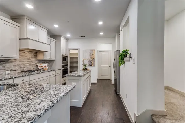 a large kitchen with kitchen island granite countertop a large counter top stainless steel appliances and cabinets