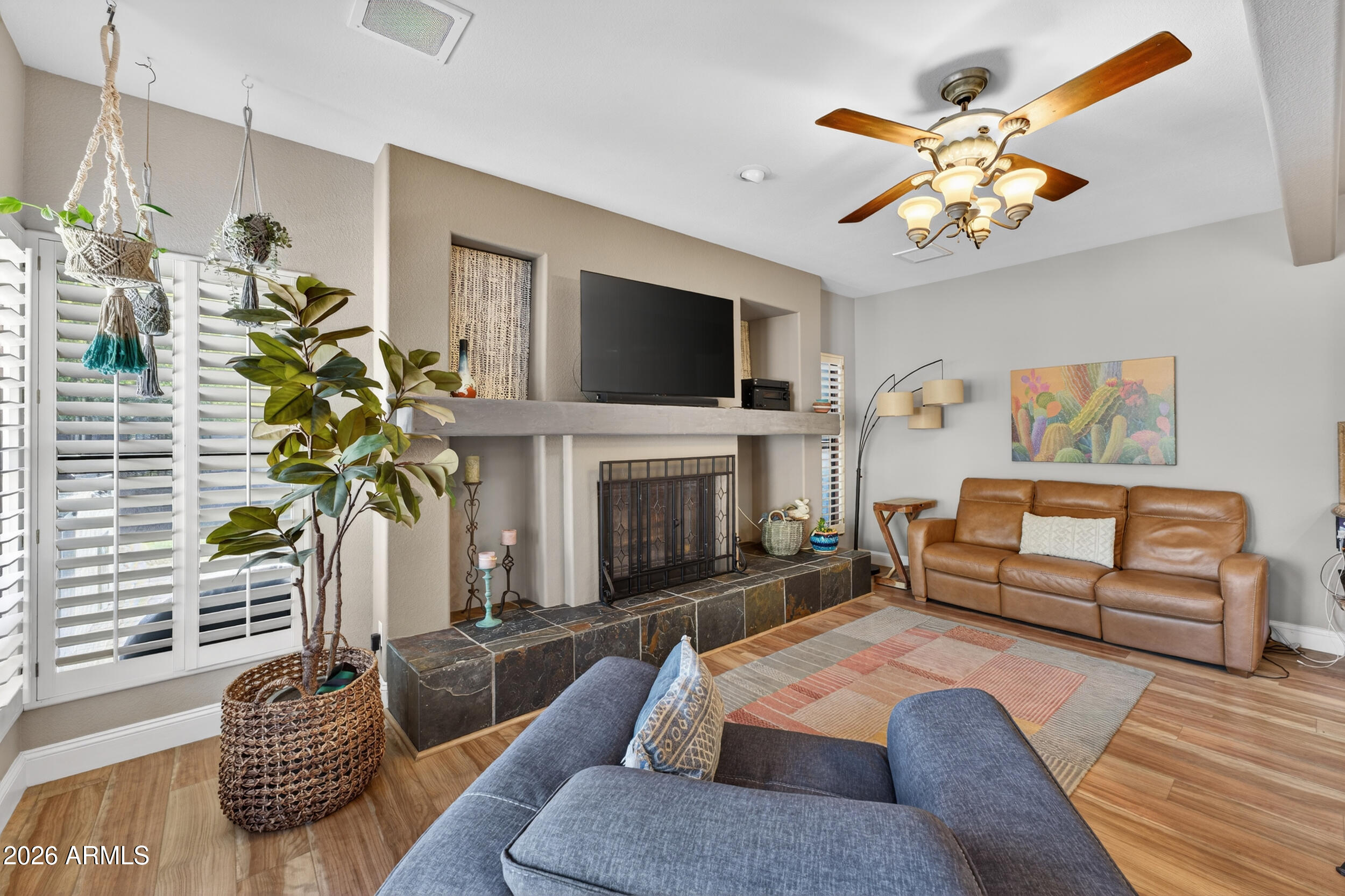 1539 East Winged Foot Road Phoenix, AZ 85022 - Photo 25 of 64 a living room with furniture a fireplace and a flat screen tv