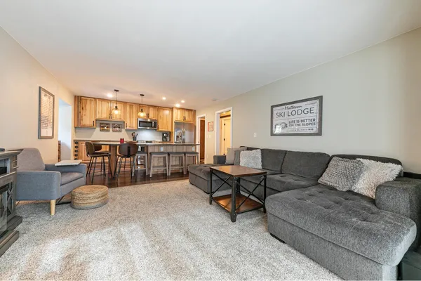 a living room with furniture and a kitchen view