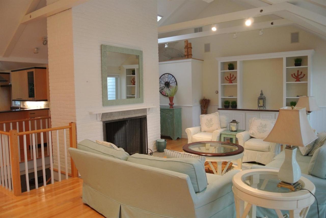 118 Wading Place Road Mashpee, MA 02649 - Photo 13 of 32 a living room with furniture a fireplace and a large mirror