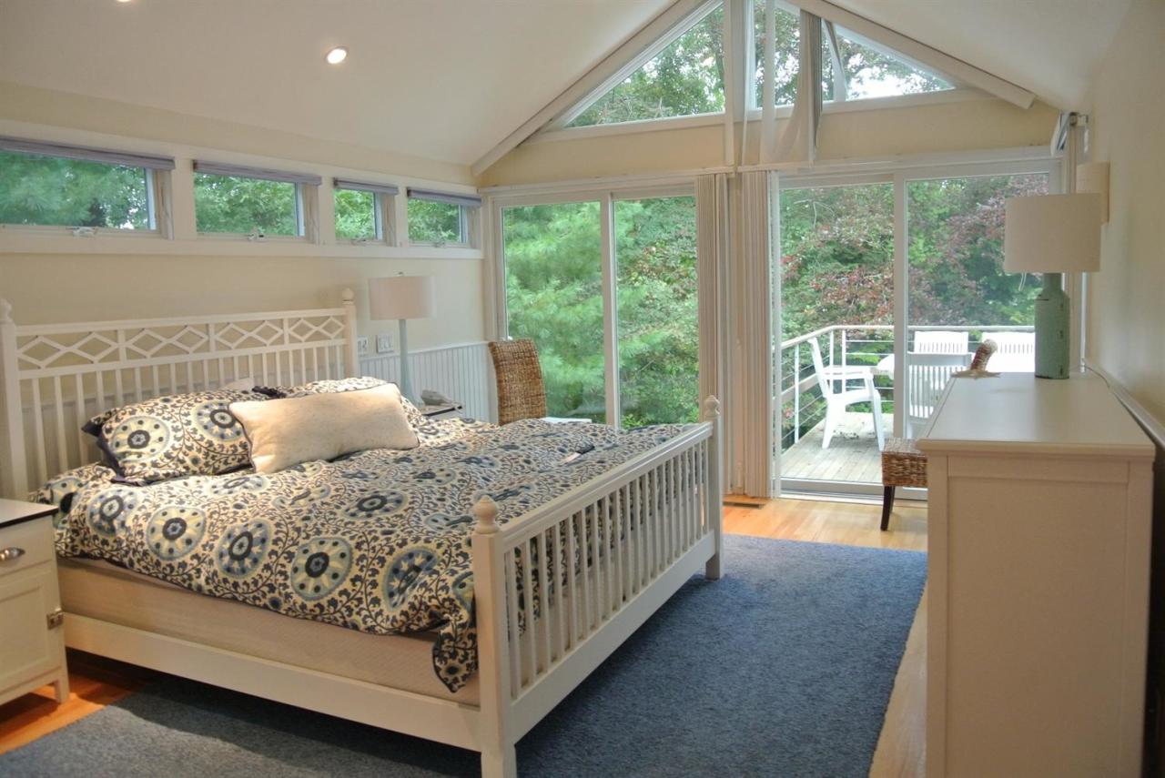 118 Wading Place Road Mashpee, MA 02649 - Photo 18 of 32 a bed sitting in a bedroom next to a large window