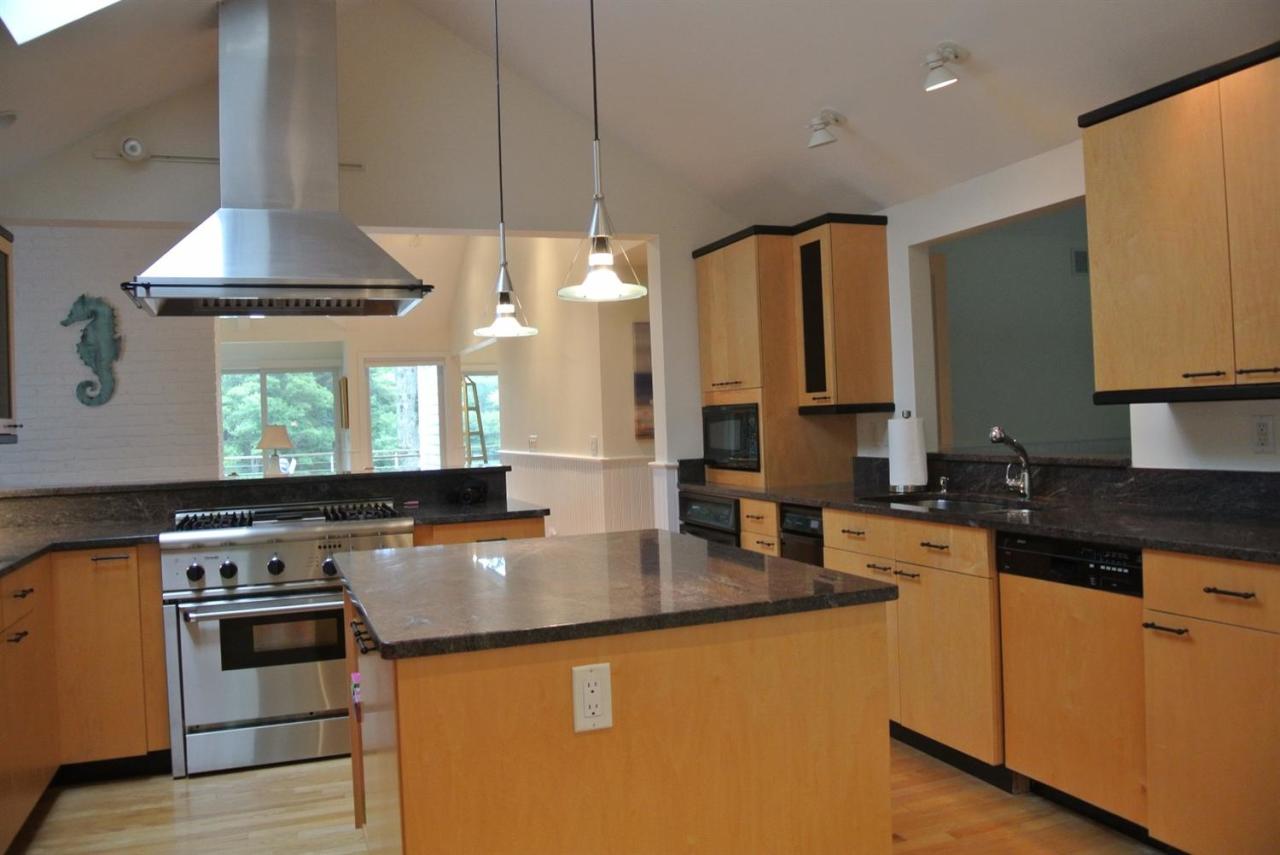 118 Wading Place Road Mashpee, MA 02649 - Photo 9 of 32 a kitchen with kitchen island granite countertop a sink stainless steel appliances and cabinets