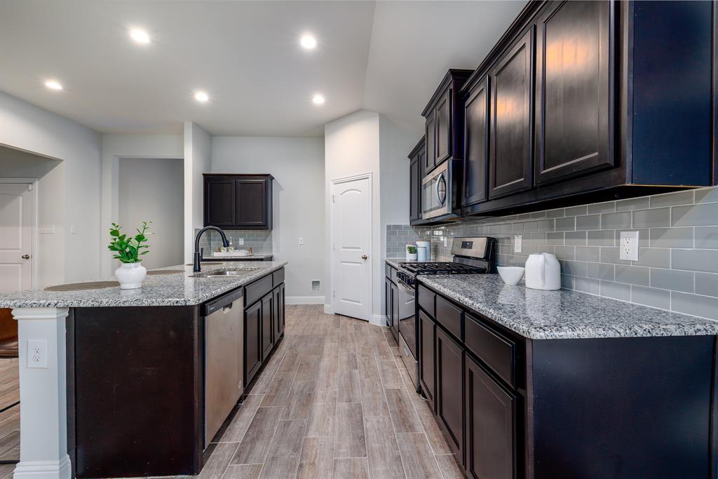 118 Sycamore Street Balch Springs, TX 75181 - Photo 12 of 34 a kitchen with granite countertop stainless steel appliances and wooden cabinets