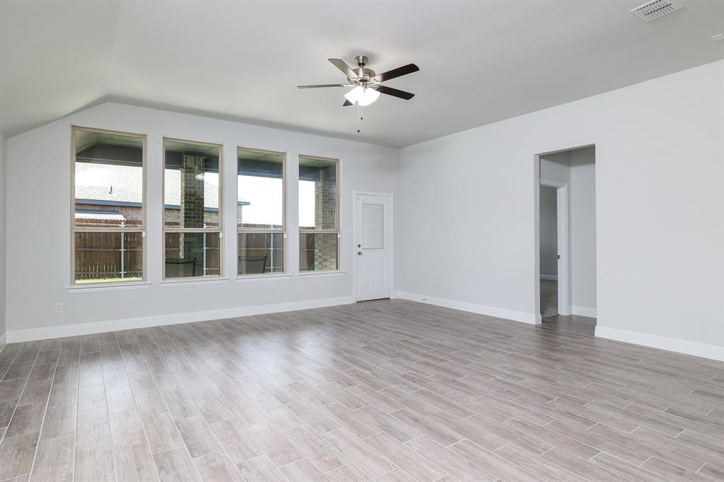 118 Sycamore Street Balch Springs, TX 75181 - Photo 9 of 34 a view of an empty room with wooden floor and a ceiling fan