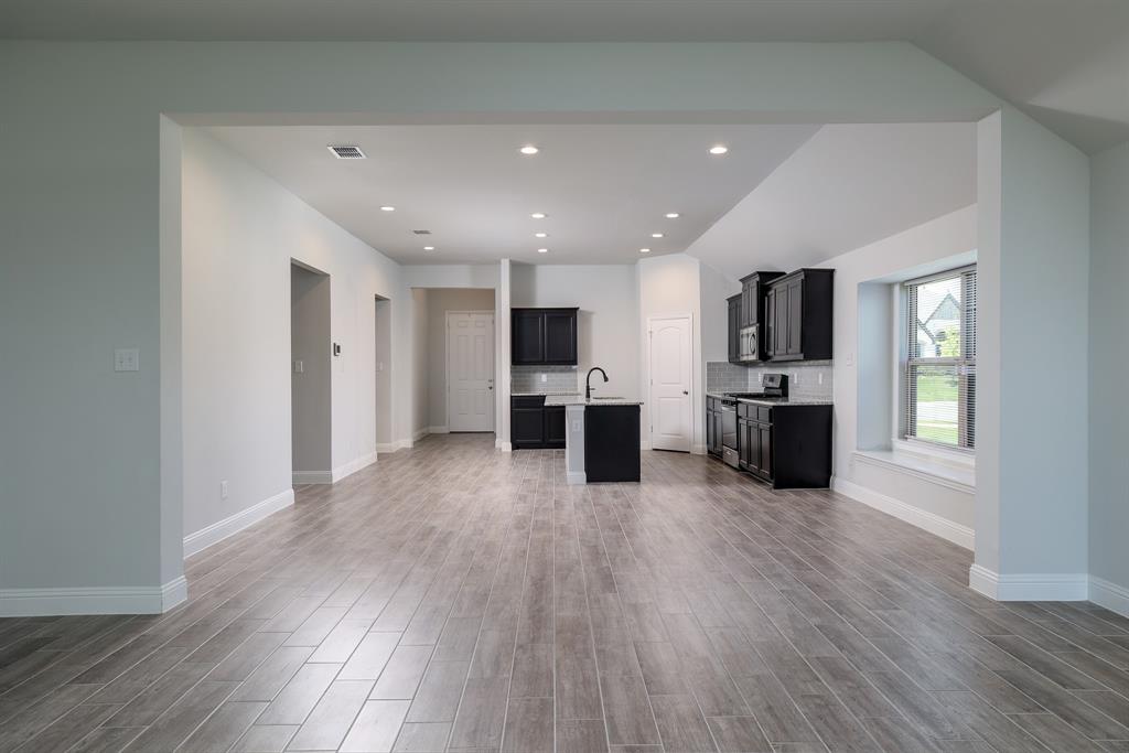 118 Sycamore Street Balch Springs, TX 75181 - Photo 10 of 34 a view of a kitchen with a sink and dishwasher a refrigerator with wooden floor