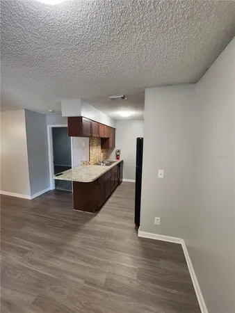a living room with kitchen view and a fireplace