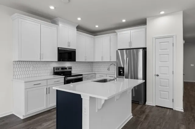 a kitchen with a sink a refrigerator a microwave and cabinets