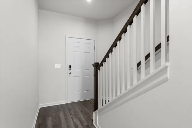 a view of a hallway with wooden floor and staircase