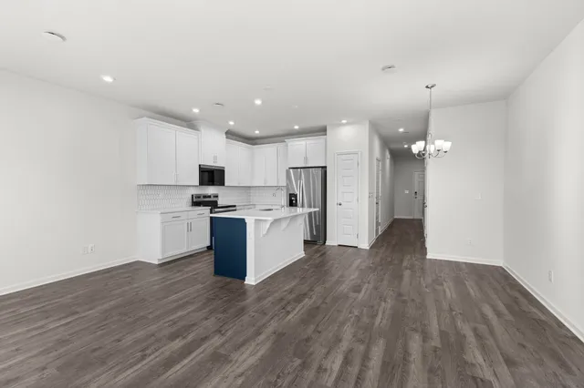 a view of kitchen with granite countertop cabinets and refrigerator
