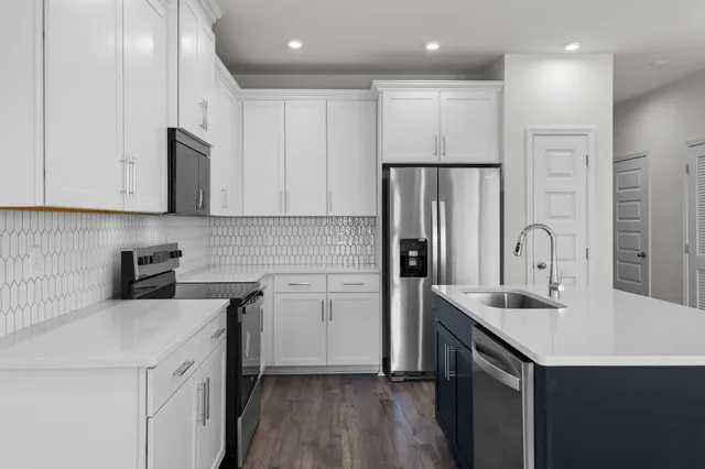 a kitchen with a sink a refrigerator and cabinets