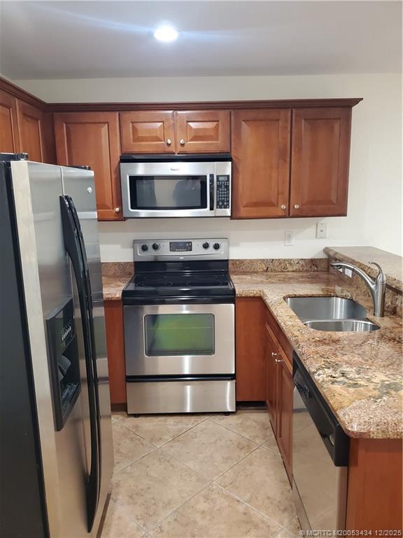 5309 Southeast Jennings Lane Stuart, FL 34997 - Photo 4 of 23 a kitchen with stainless steel appliances granite countertop a stove a sink dishwasher a refrigerator and a microwave
