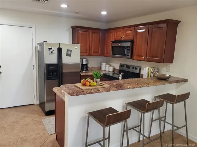a kitchen with stainless steel appliances granite countertop a refrigerator stove a sink and dishwasher