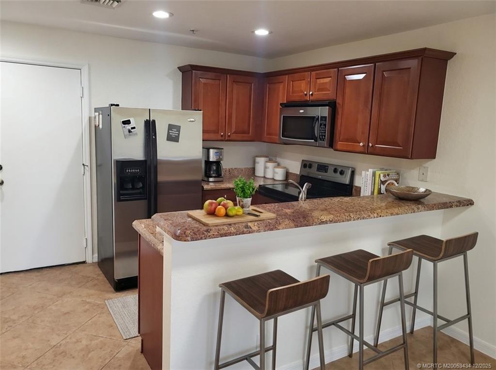 5309 Southeast Jennings Lane Stuart, FL 34997 - Photo 5 of 23 a kitchen with stainless steel appliances granite countertop a refrigerator a stove top oven a sink and dishwasher