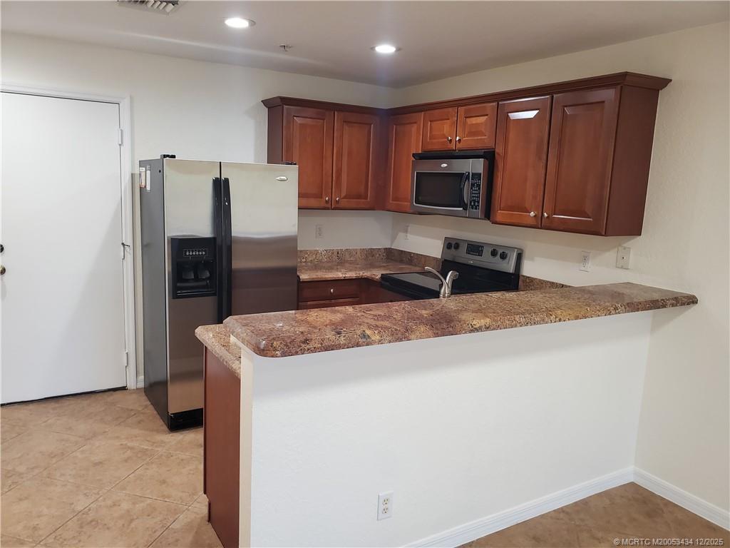 5309 Southeast Jennings Lane Stuart, FL 34997 - Photo 6 of 23 a kitchen with stainless steel appliances granite countertop a refrigerator stove a sink and dishwasher