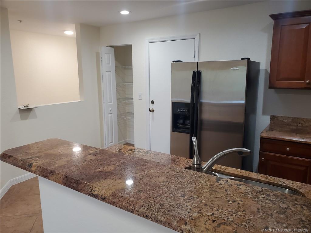 5309 Southeast Jennings Lane Stuart, FL 34997 - Photo 7 of 23 a kitchen with stainless steel appliances granite countertop a refrigerator and a stove top oven