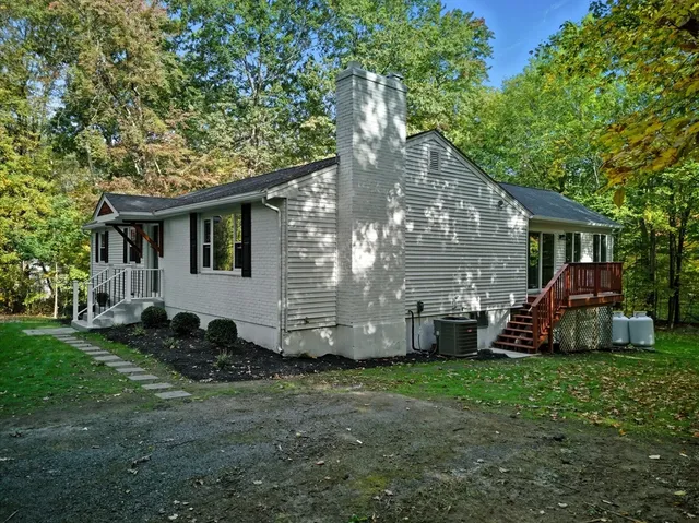 a view of house with a yard and deck