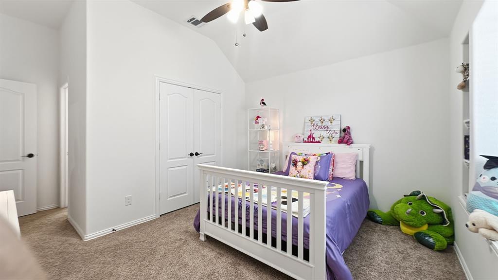 5216 Troupe Road McKinney, TX 75071 - Photo 30 of 40 Bedroom featuring vaulted ceilings, carpet flooring, a ceiling fan, a double-door closet, and an integrated wall niche