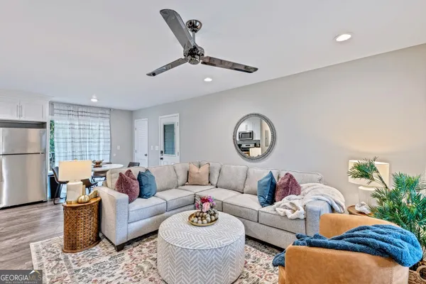 a living room with furniture kitchen view and a window