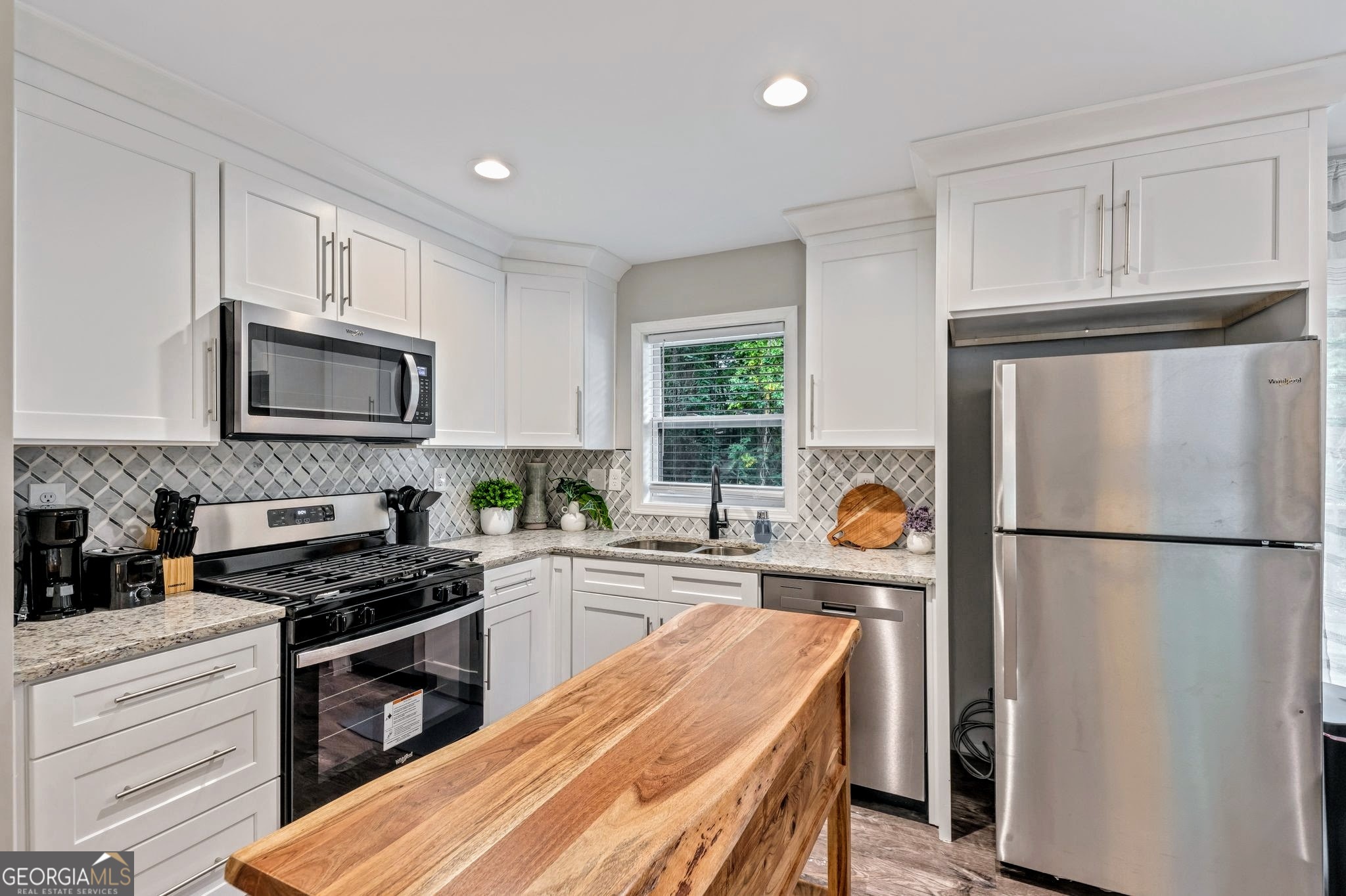 3590 Ponderosa Lane Powder Springs, GA 30127 - Photo 6 of 25 a kitchen with stainless steel appliances granite countertop a refrigerator stove a sink dishwasher and microwave with cabinets