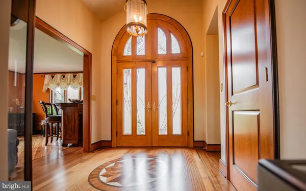 an entryway with wooden floor and a chandelier
