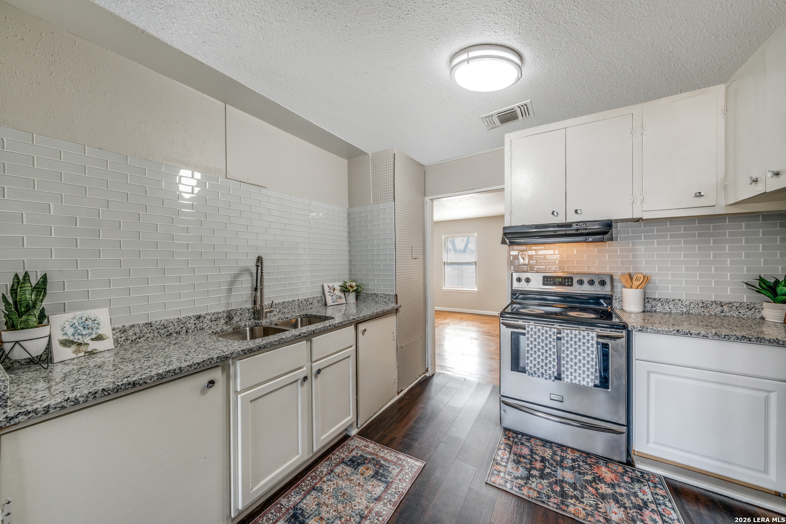 2307 Basse Road San Antonio, TX 78213 - Photo 5 of 17 a kitchen with granite countertop a sink a stove and cabinets