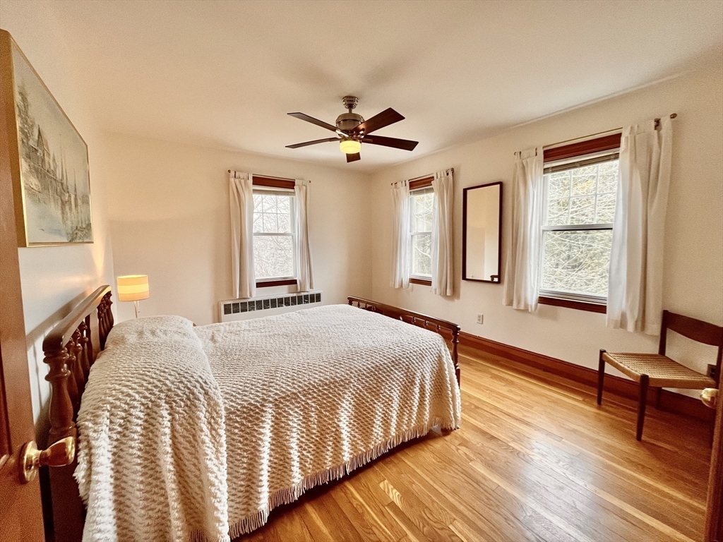 81 Topsfield Road Ipswich, MA 01938 - Photo 14 of 32 a bedroom with a bed and wooden floor
