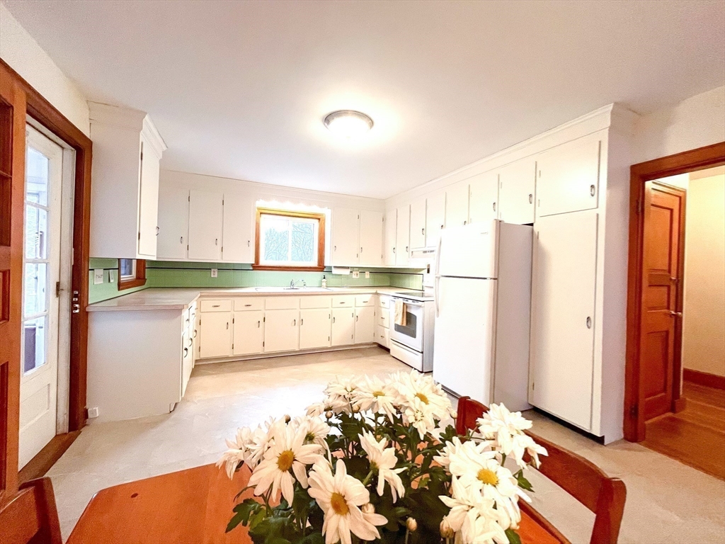 81 Topsfield Road Ipswich, MA 01938 - Photo 4 of 32 a large kitchen with a refrigerator and white cabinets