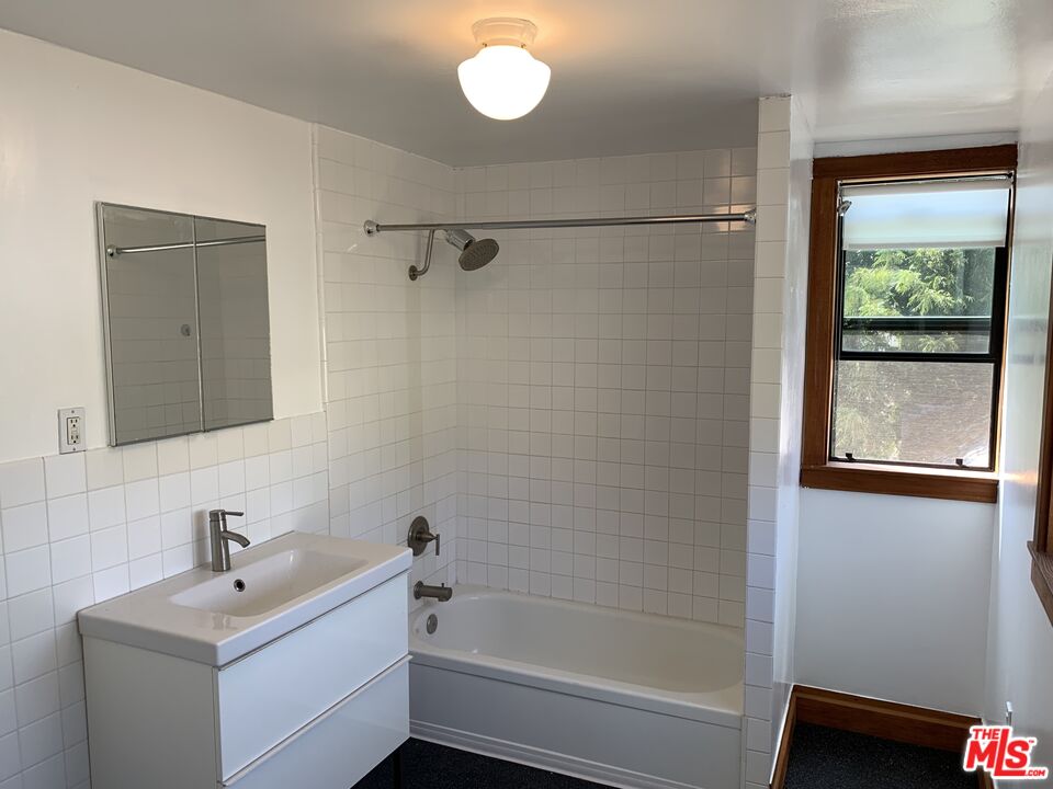 1107 Waterloo Street Los Angeles, CA 90026 - Photo 5 of 20 a bathroom with a sink a mirror and a bathtub