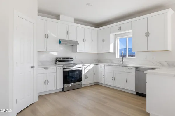 a kitchen with granite countertop white cabinets and white appliances