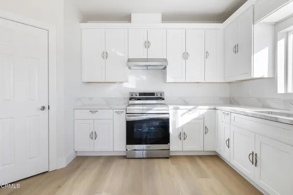 a kitchen with granite countertop white cabinets and stainless steel appliances