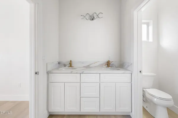 a bathroom with a sink vanity mirror and toilet