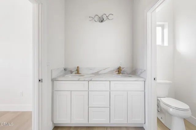 a bathroom with a sink vanity mirror and toilet