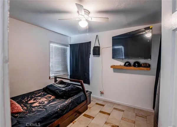 a bedroom with bed and a flat screen tv