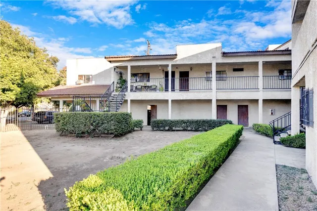a front view of a house with a yard and potted plants
