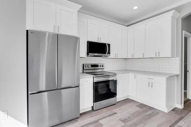 a view of a kitchen with wooden floor and a refrigerator