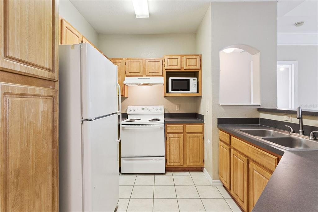 3446 Soho Street, Unit 303 Orlando, FL 32835 - Photo 12 of 47 a kitchen with a refrigerator sink and microwave