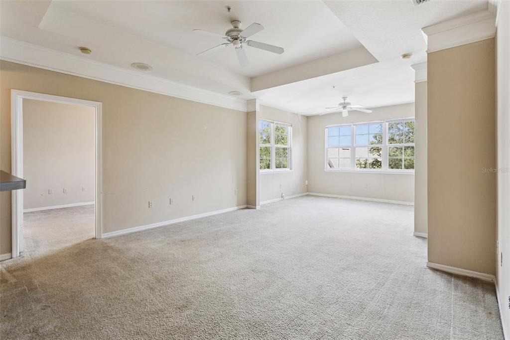 3446 Soho Street, Unit 303 Orlando, FL 32835 - Photo 15 of 47 a view of a big room with windows and chandelier fan