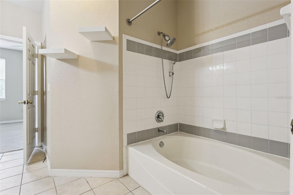 3446 Soho Street, Unit 303 Orlando, FL 32835 - Photo 22 of 47 a white bath tub sitting next to a shower